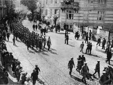 Pochód Strzelców ulicami Lwowa w 1913 r. podczas uroczystych obchodów 50. rocznicy wybuchu Powstania Styczniowego. Na przedzie, w grupie trzech wojskowych, maszeruje z wyciągniętą przed siebie ręką Józef Piłsudski. Fot. z miesięcznika WPiS.