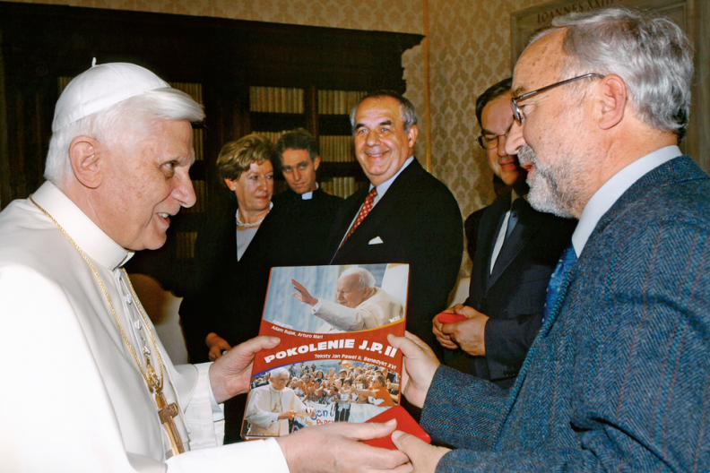 Papież Benedykt XVI przyjmuje na audiencji fotografa papieskiego Adama Bujaka, który prezentuje mu swoją książkę 