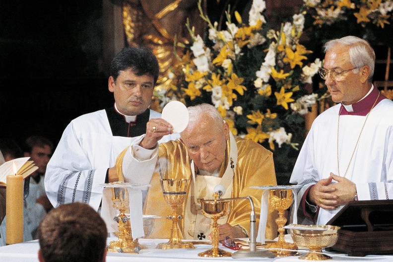 Ojciec Święty Jan Paweł II odprawia Mszę św. w Sanktuarium Matki Bożej w Kalwarii Zebrzydowskiej. 19 sierpnia 2002r., ostatnia pielgrzymka apostolska do Polski. Towarzyszą mu ks. prał. Konrad Krajewski (z lewej) i bp Piero Marini. Fot. Adam Bujak, „Dekalog”, Biały Kruk, 2020. 