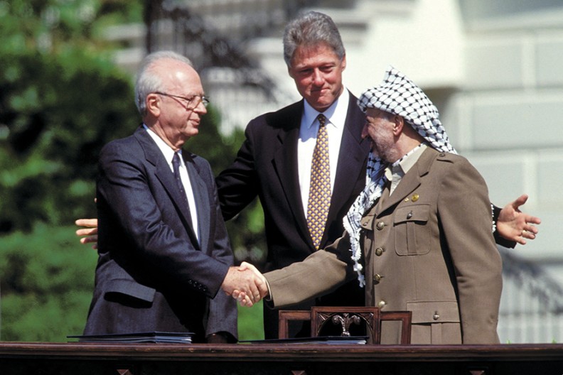 Premier Izraela Icchak Rabin i przewodniczący Organizacji Wyzwolenia Palestyny Jaser Arafat (od 1996 r. prezydent Autonomii Palestyńskiej) podają sobie ręce po podpisaniu porozumienia z Oslo z 13 września 1993 r. Towarzyszy im prezydent USA Bill Clinton, fot. z podręcznika 