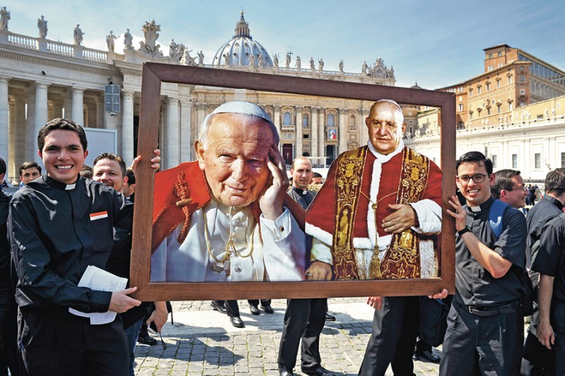 Młodzi księża z portretami nowych świętych Jana Pawła II i Jana XXIII., fot. Adama Bujaka