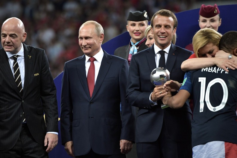 Od lewej: przewodniczący FIFA Gianni Infantino, prezydent Rosji Władimir Putin, prezydent Francji Emmanuel Macron oraz Kylian Mbappé (tyłem), który odbiera nagrodę dla najlepszego młodego piłkarza Mistrzostw Świata FIFA 2018 w Rosji. Fot. Wikipedia