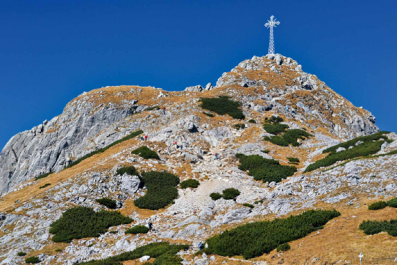 Krzyż na szczycie Śpiącego Rycerza, jak nazywany jest Giewont, najbardziej charakterystyczny szczyt Tatr Zachodnich, wznoszący się na wysokość 1894 m n.p.m. fot. Adam Bujak z książki 