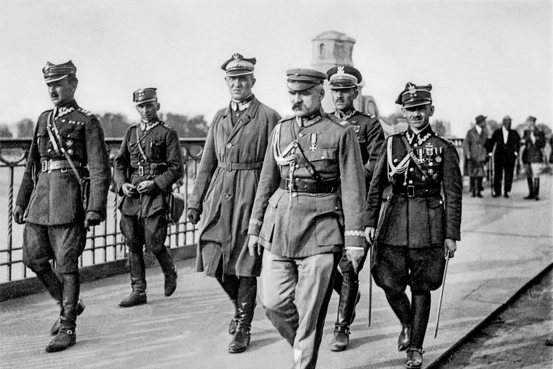 12 maja 1926, J&oacute;zef Piłsudski przed spotkaniem z prezydentem RP Stanisławem Wojciechowskim na moście Poniatowskiego. Od lewej: Kazimierz Stamirowski, Marian Żebrowski, Gustaw Orlicz-Dreszer, J&oacute;zef Piłsudski, Władysław Jaroszewicz i Michał Galiński. Fot. domena publiczna via Wikimedia.