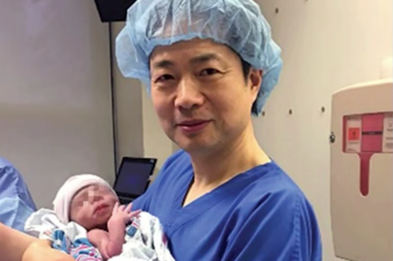Dr Zuhang trzymający dziecko stworzone w probówce z kodu genetycznego trzech rodziców. Fot.: własna na podstawie filmu YT